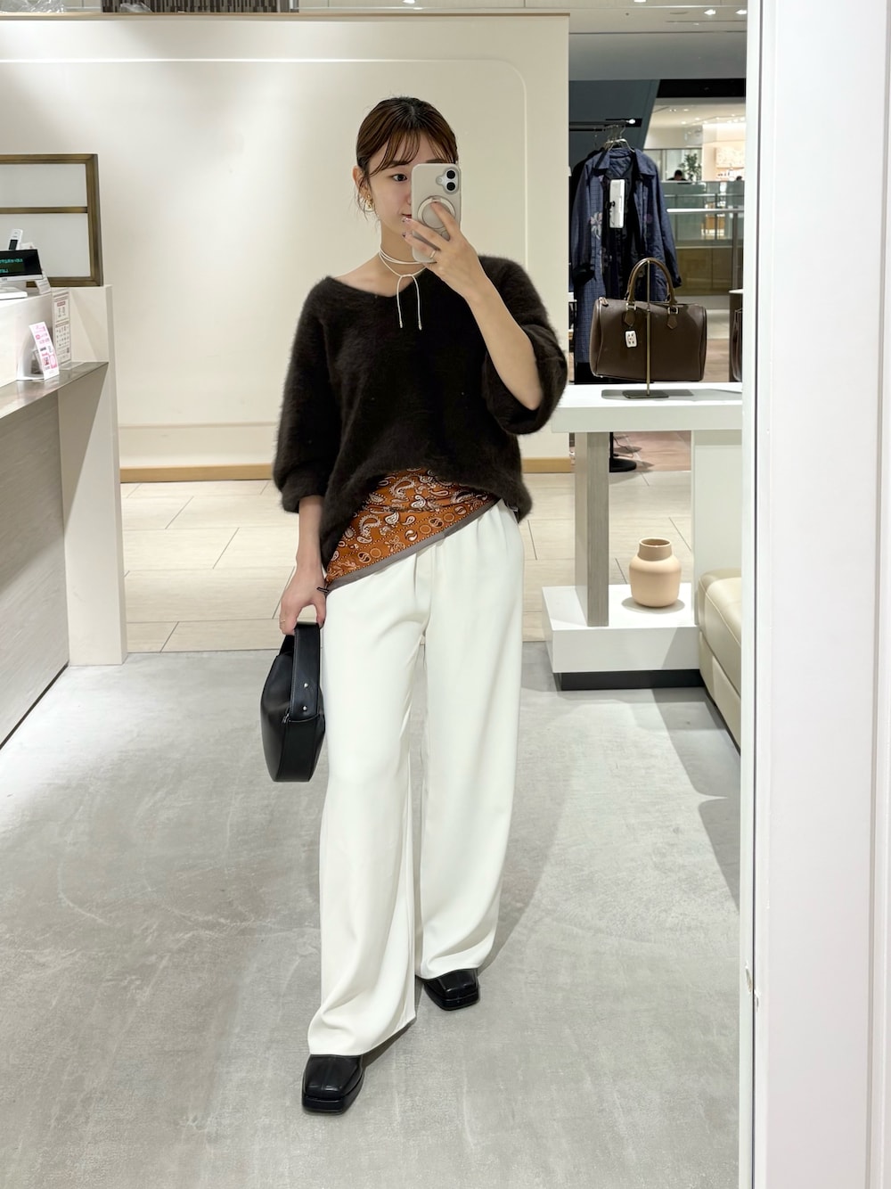 ブラウン系のニット/セーター、ブラック系のその他シューズ、ブラック系のトートバッグを着用したレディースの秋コーディネートの1枚目の写真