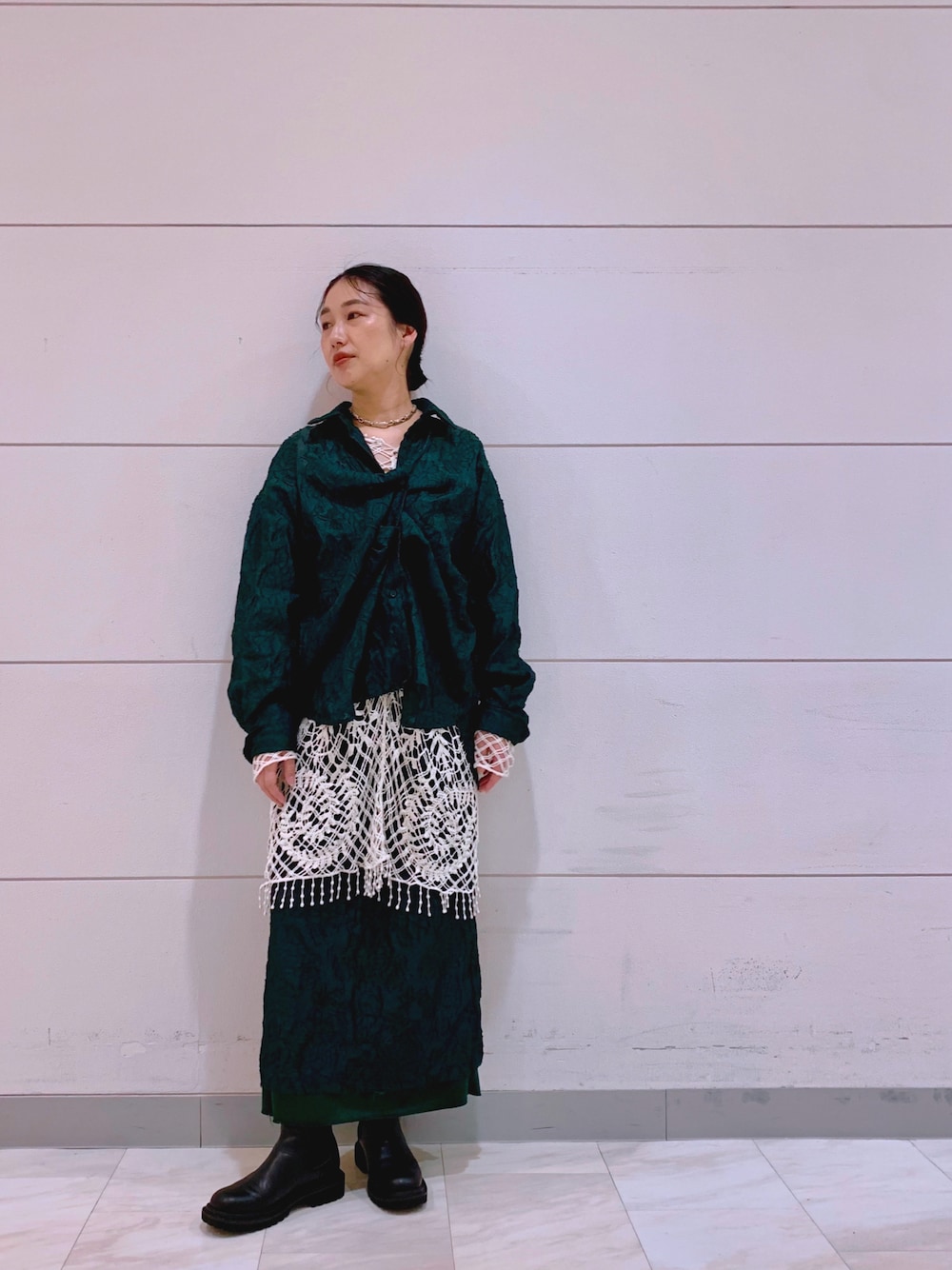 ブラック系のブーツ、グリーン系のスカート、グリーン系のシャツ/ブラウスを着用したレディースの秋コーディネートの1枚目の写真