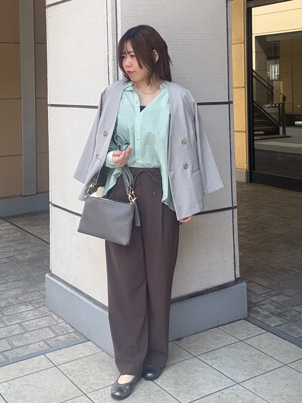 グレー系のショルダーバッグ、ブラウン系のその他パンツ、ベージュ系のダウンジャケット/コートを着用したレディースの春コーディネートの1枚目の写真