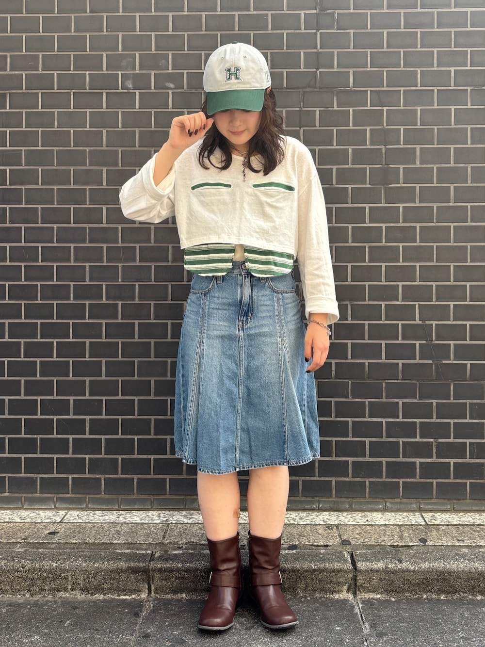 ブルー系のデニムスカート、グレー系のキャップを着用したレディースの夏コーディネートの1枚目の写真