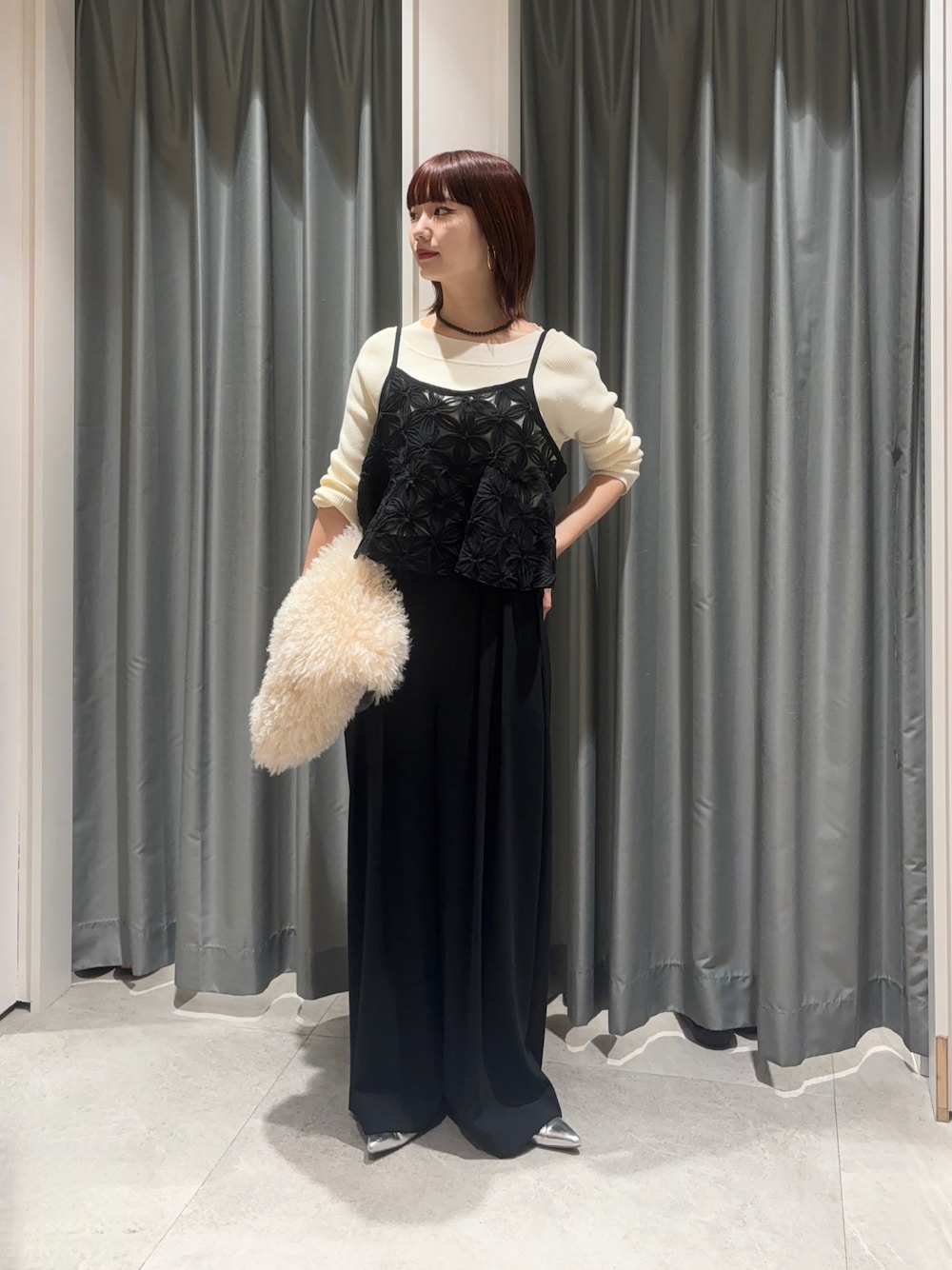 ブラック系のスラックス、ブラック系のシャツ/ブラウス、ホワイト系のニット/セーターを着用したレディースの秋コーディネートの1枚目の写真