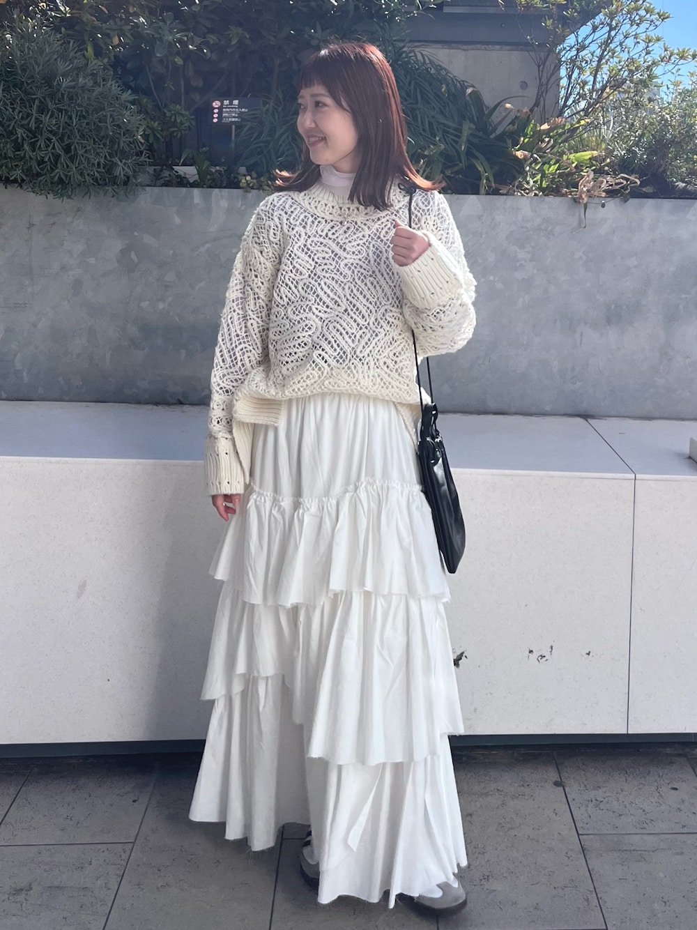 ホワイト系のニット/セーター、ホワイト系のスカート、パープル系のTシャツ/カットソーを着用したレディースの冬コーディネートの1枚目の写真