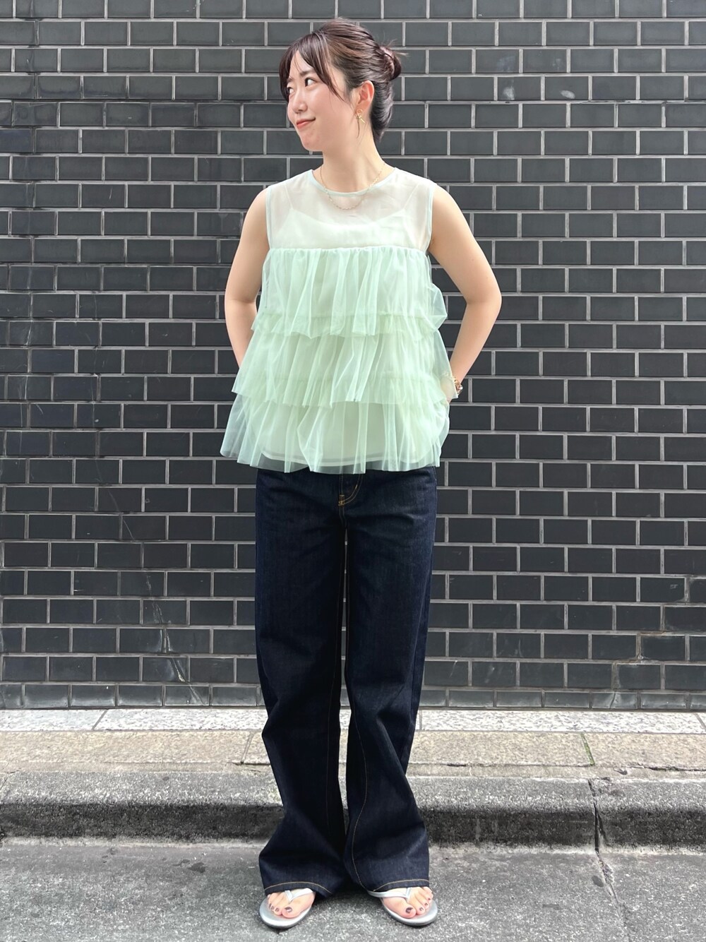 グリーン系のシャツ/ブラウス、ブルー系のデニムパンツを着用したレディースの夏コーディネートの1枚目の写真