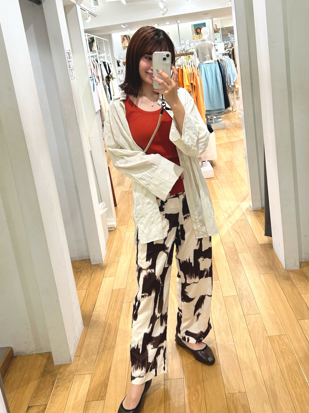 ホワイト系のTシャツ/カットソー、ブラウン系のその他パンツ、オレンジ系のタンクトップを着用したレディースの春コーディネートの1枚目の写真