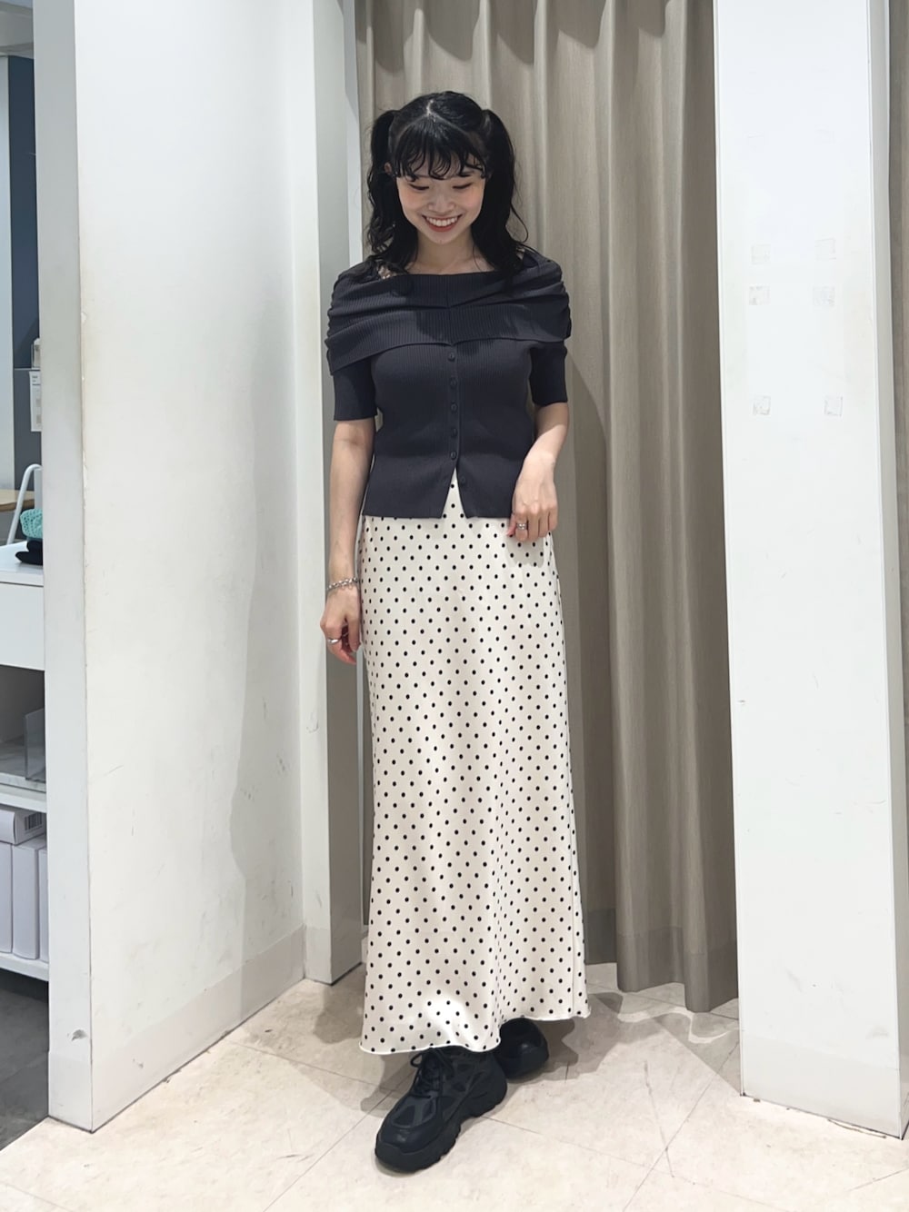 グレー系のニット/セーター、ホワイト系のスカートを着用したレディースの夏コーディネートの1枚目の写真
