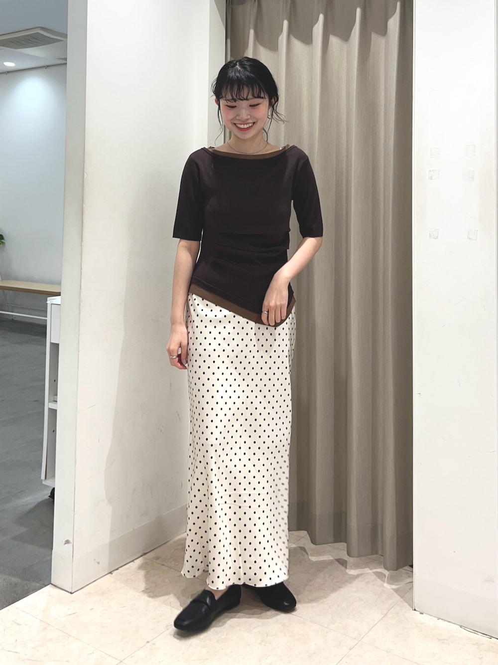 ブラウン系のニット/セーター、ホワイト系のスカート、ブラック系のローファーを着用したレディースの春コーディネートの1枚目の写真