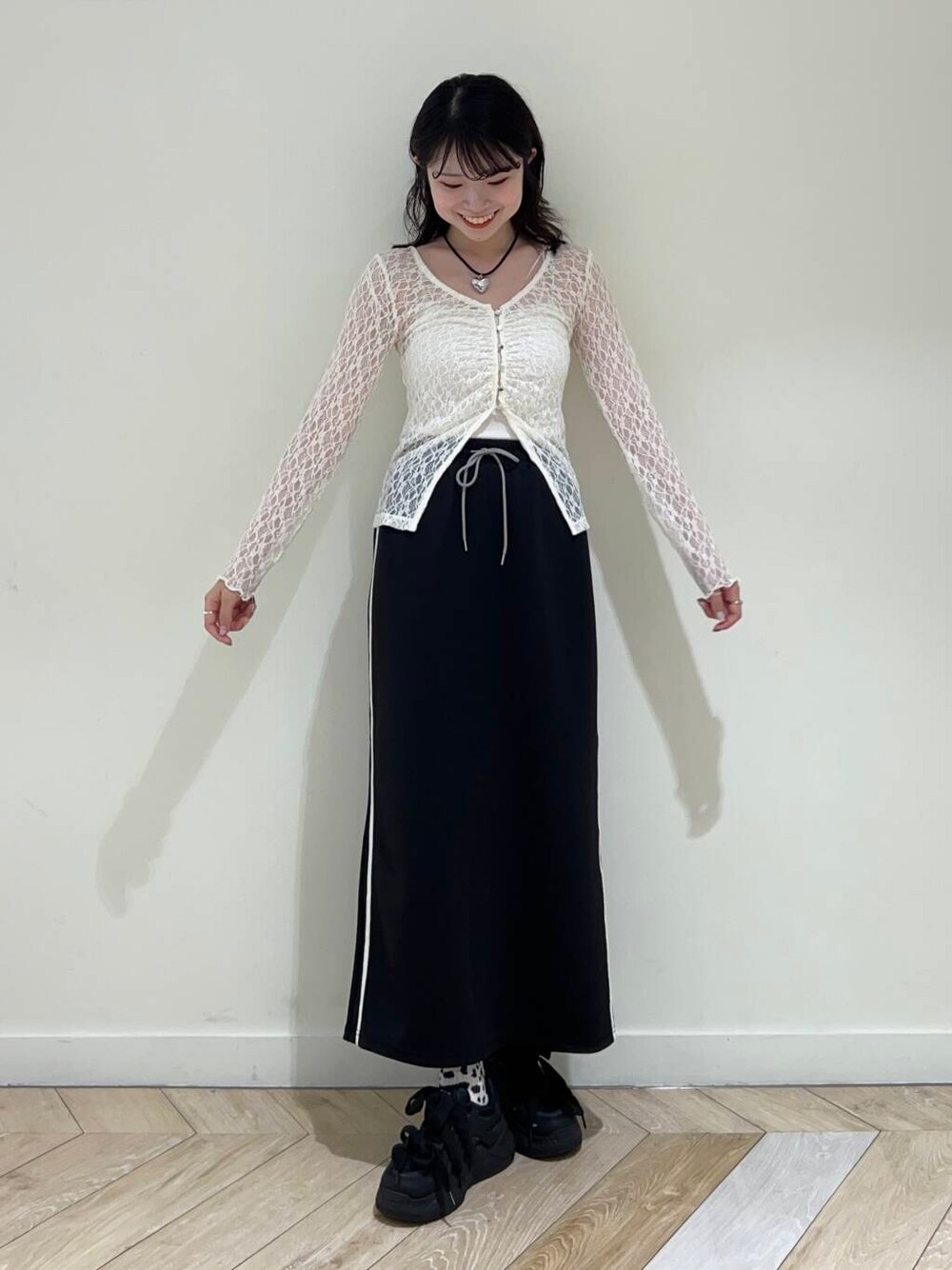 ブラック系のスカート、ホワイト系のTシャツ/カットソーを着用したレディースの秋コーディネートの1枚目の写真