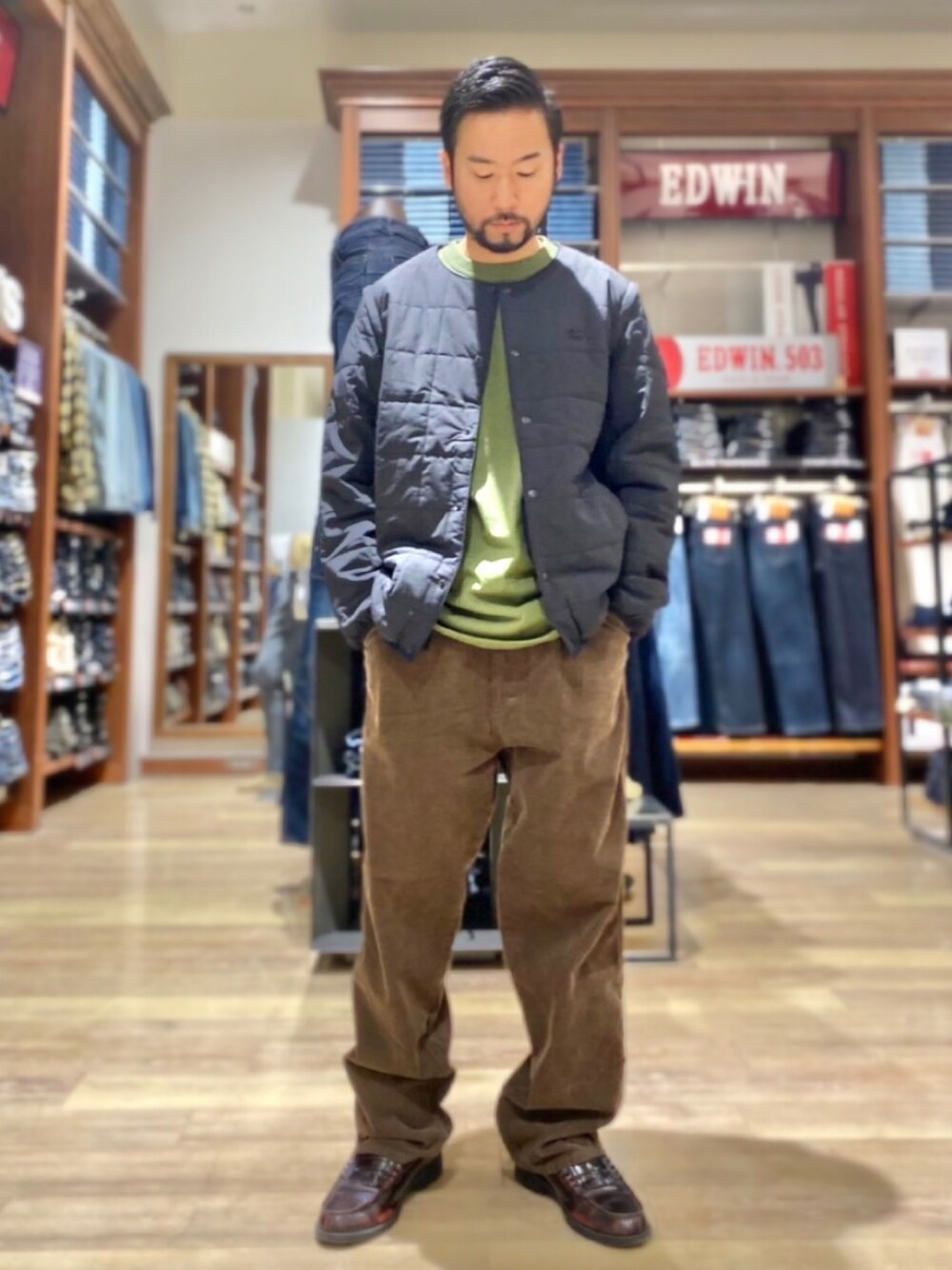 ブラック系のノーカラージャケット、グリーン系のTシャツ/カットソーを着用したメンズの秋コーディネートの1枚目の写真