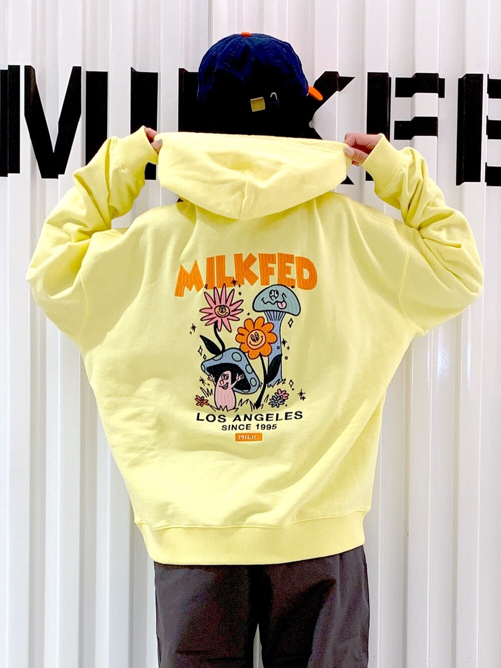 グレー系のその他パンツ、イエロー系のパーカー、オレンジ系のキャップを着用したレディースの冬コーディネートの1枚目の写真