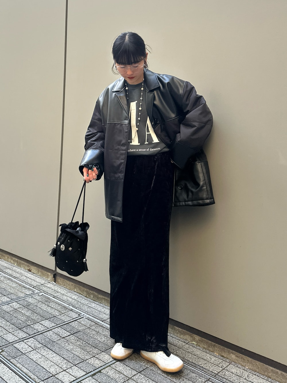 グリーン系のスウェット、ブラック系のスカート、ブラック系のハンドバッグを着用したレディースの冬コーディネートの1枚目の写真