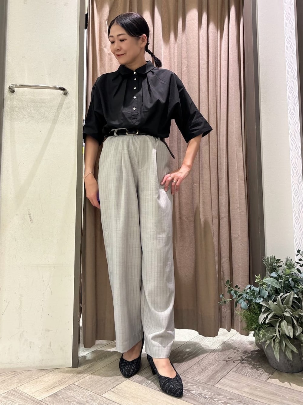 グレー系のその他パンツ、ブラック系のパンプス、ブラック系のベルトを着用したレディースの秋コーディネートの1枚目の写真