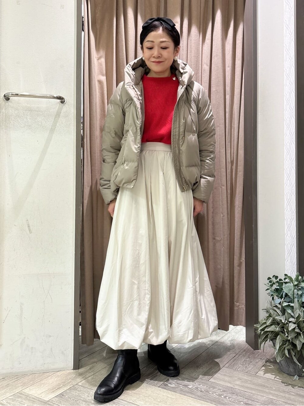 レッド系のニット/セーターを着用したレディースの冬コーディネートの1枚目の写真