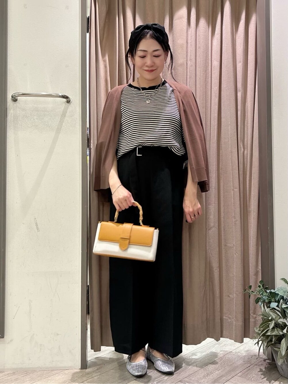 ブラウン系のカーディガン/ボレロ、ブラック系のニット/セーター、ブラック系のその他パンツを着用したレディースの春コーディネートの1枚目の写真
