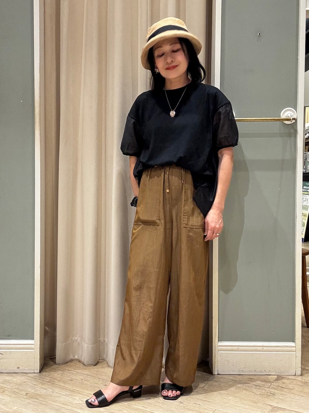 ブラック系のTシャツ/カットソー、イエロー系のその他パンツ、ブラウン系のハットを着用したレディースの春コーディネートの1枚目の写真