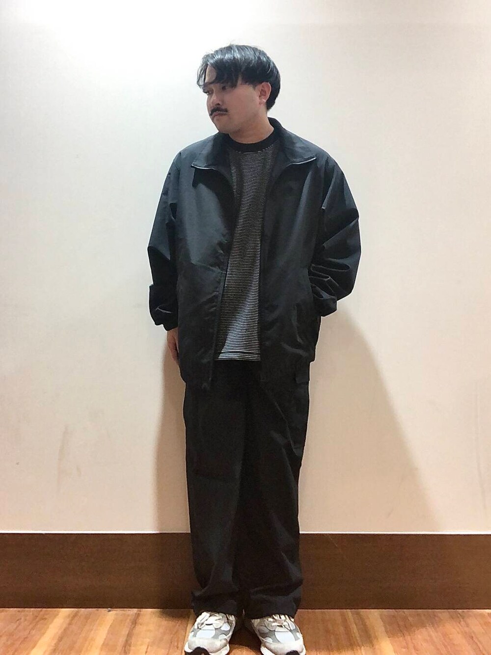 ブラック系のTシャツ/カットソー、ブラック系のブルゾン、ブラック系のカーゴパンツを着用したメンズの秋コーディネートの1枚目の写真