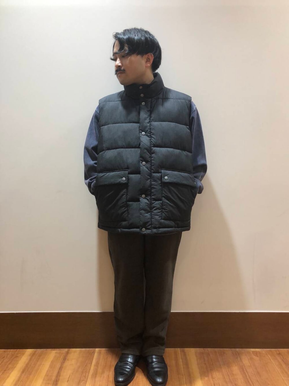ブラウン系のその他パンツ、ブラック系のダウンベスト、ブルー系のスウェットを着用したメンズの秋コーディネートの1枚目の写真