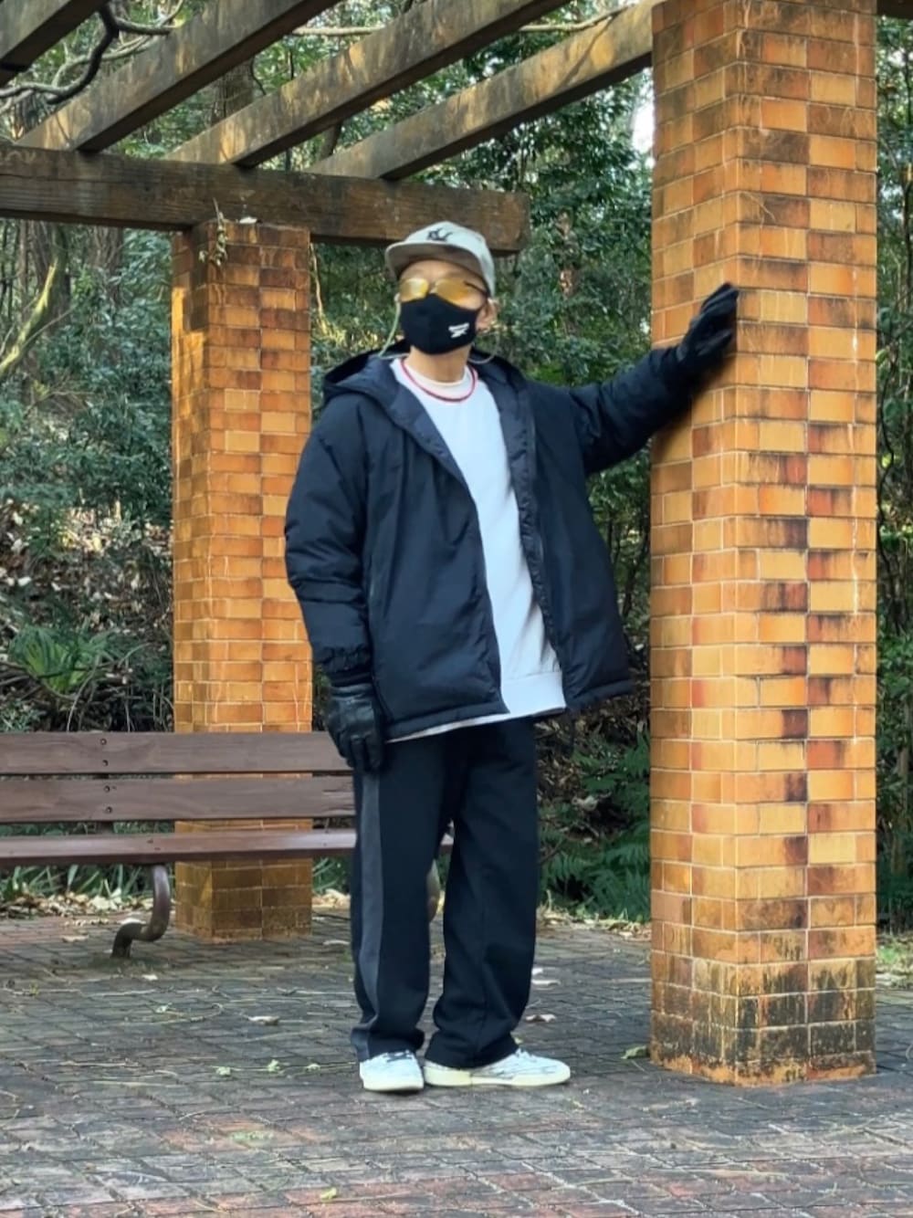 グレー系のスニーカー、ブラック系のスウェットパンツ、ベージュ系のTシャツ/カットソーを着用したメンズの冬コーディネートの1枚目の写真