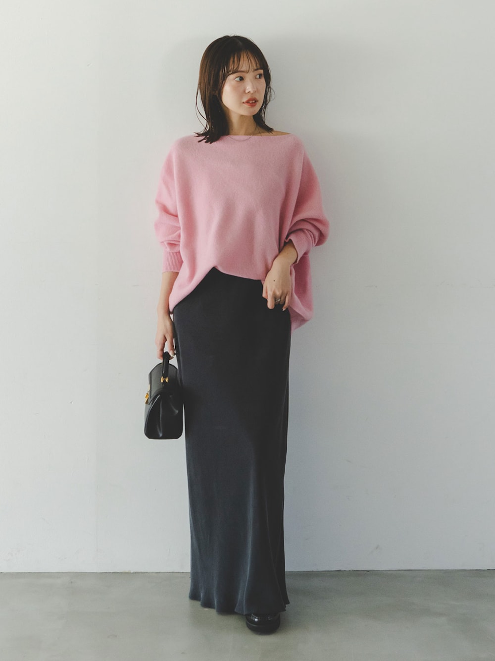 ピンク系のニット/セーター、ブルー系のスカートを着用したレディースの秋コーディネートの1枚目の写真