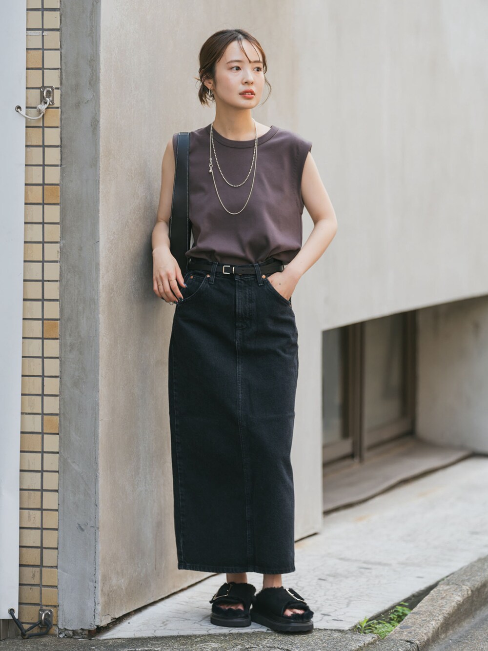 ブラウン系のTシャツ/カットソー、ブラック系のデニムスカート、ブラック系のサンダルを着用したレディースの夏コーディネートの1枚目の写真