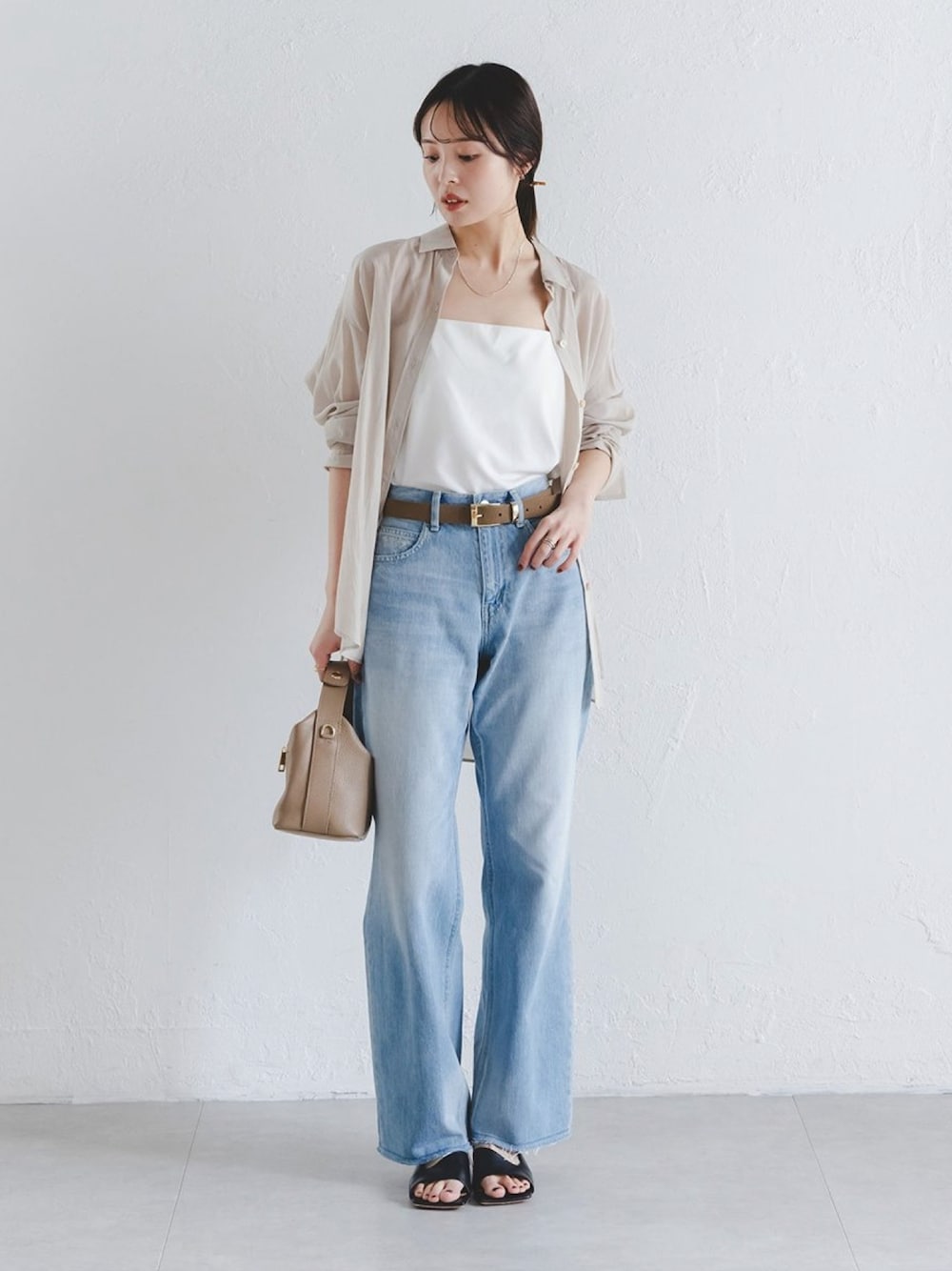 ベージュ系のシャツ/ブラウス、ホワイト系のキャミソール、ブルー系のデニムパンツを着用したレディースの春コーディネートの1枚目の写真