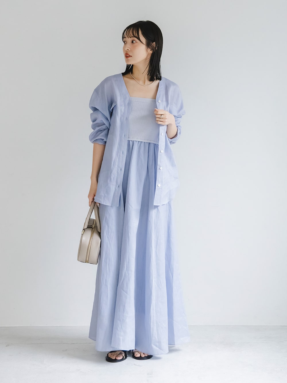 ブルー系のワンピース、ブルー系のシャツ/ブラウス、ベージュ系のショルダーバッグを着用したレディースの夏コーディネートの1枚目の写真