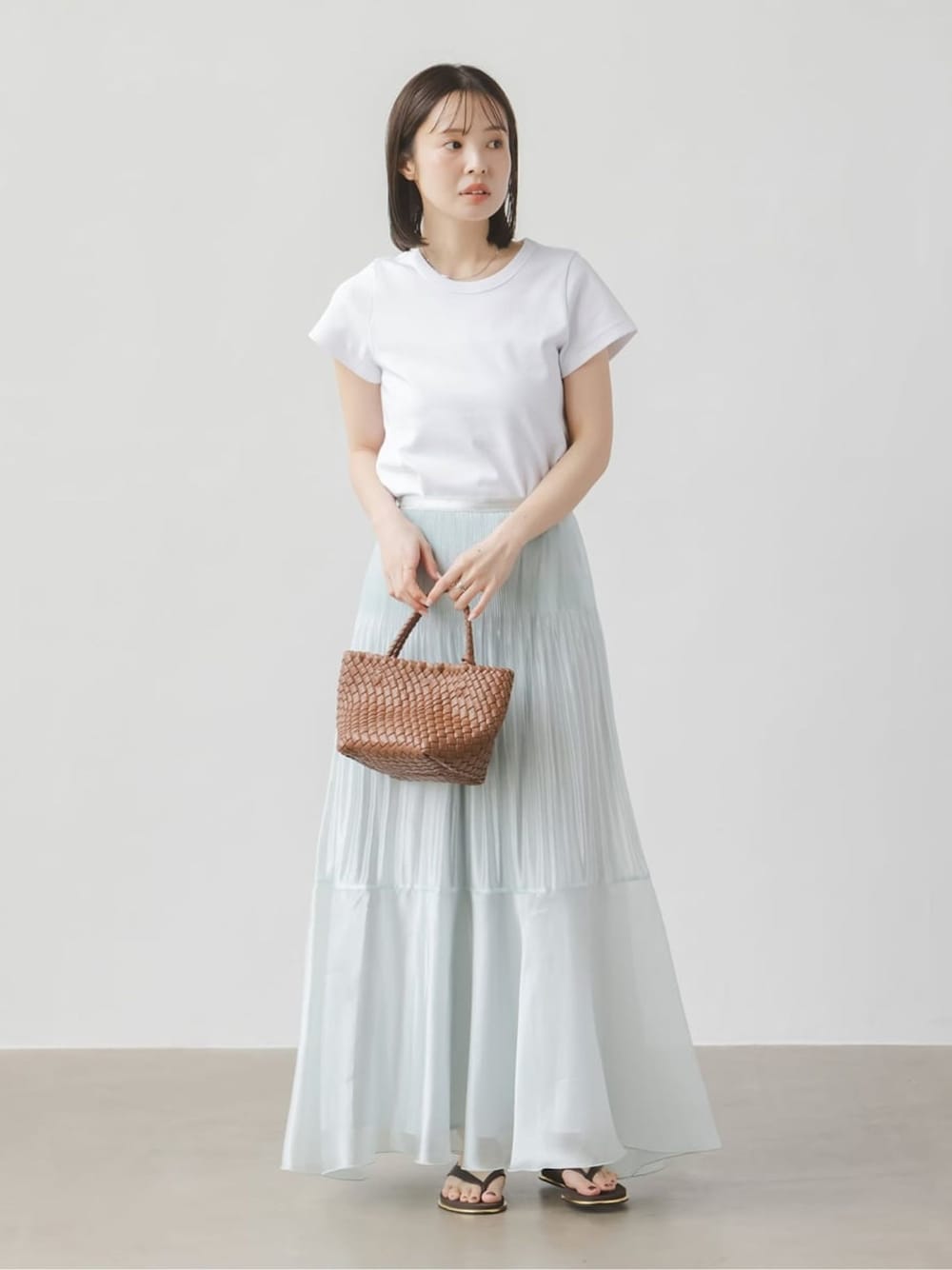 ブルー系のスカート、ホワイト系のTシャツ/カットソー、ホワイト系のTシャツ/カットソーを着用したレディースの春コーディネートの1枚目の写真