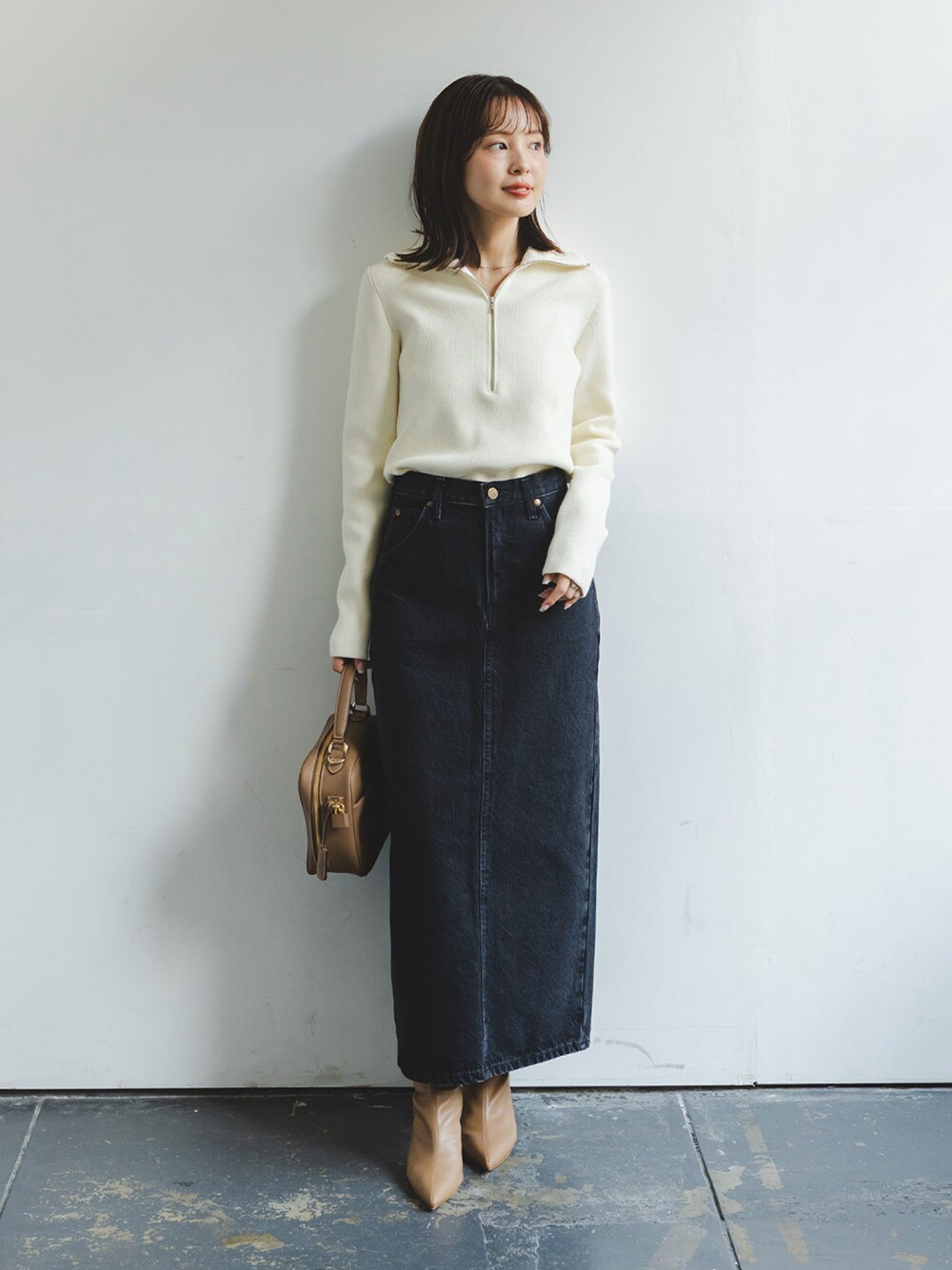 ホワイト系のニット/セーター、ブラック系のデニムスカート、イエロー系のショルダーバッグを着用したレディースの秋コーディネートの1枚目の写真