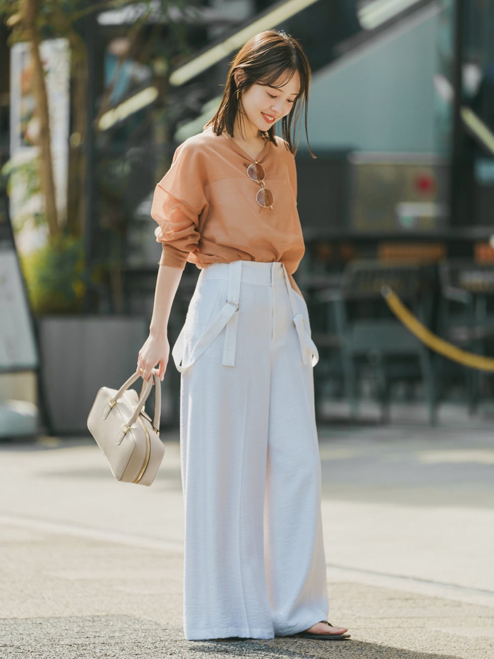 イエロー系のニット/セーター、ホワイト系のその他パンツ、ベージュ系のショルダーバッグを着用したレディースの春コーディネートの1枚目の写真