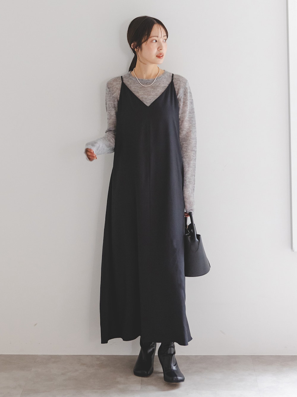 ブラック系のワンピース、ブラック系のブーツ、ブラック系のショルダーバッグを着用したレディースの冬コーディネートの1枚目の写真