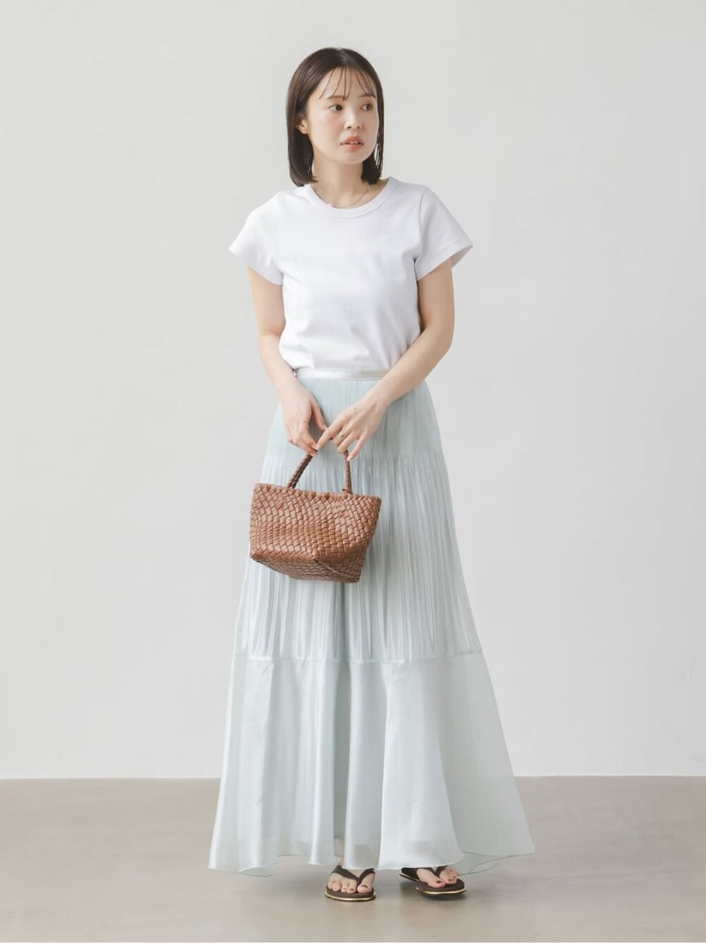 ブルー系のスカート、ホワイト系のTシャツ/カットソー、ホワイト系のTシャツ/カットソーを着用したレディースの春コーディネートの1枚目の写真