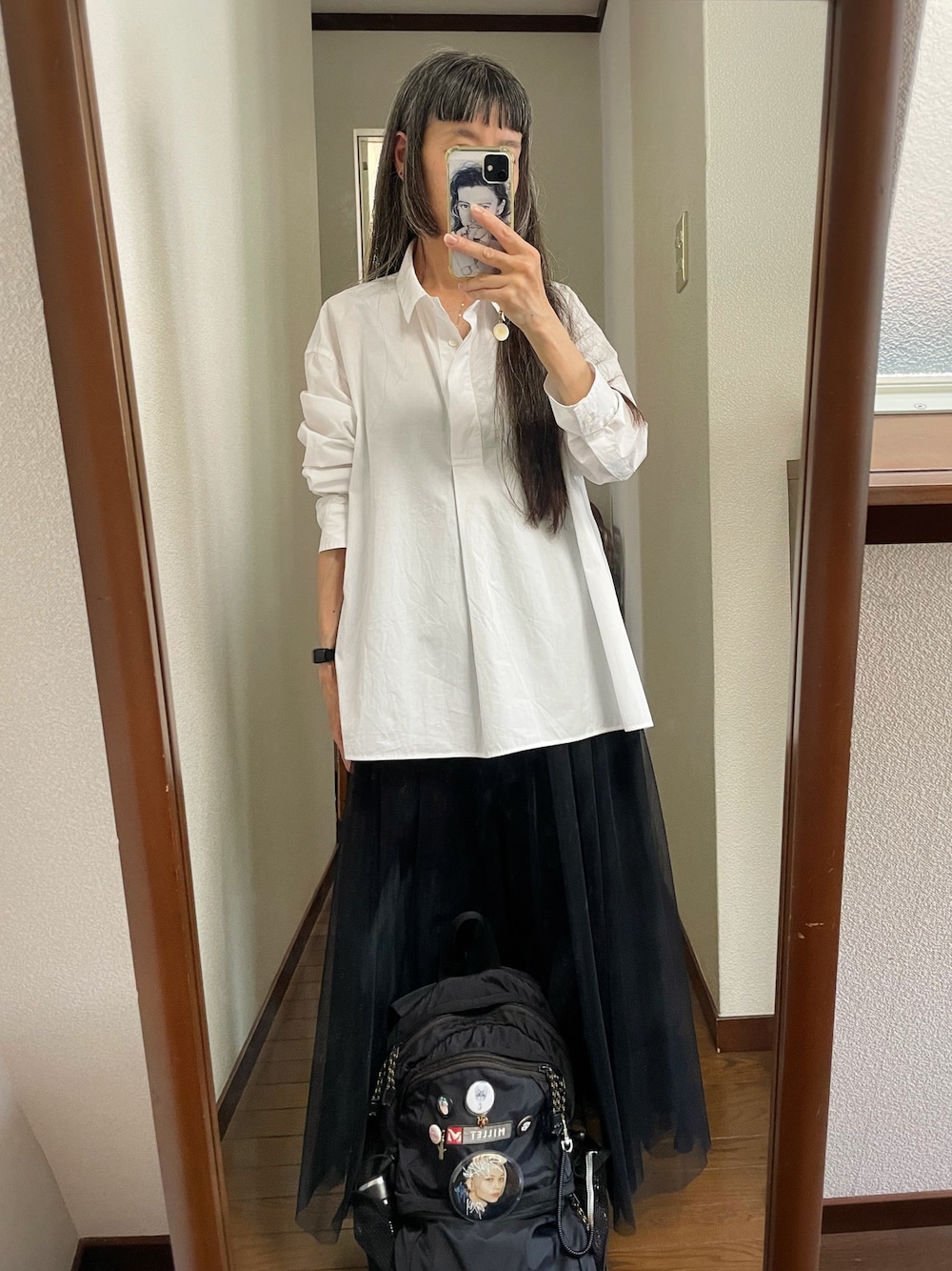 ホワイト系のシャツ/ブラウス、ブラック系のスカート、ブラック系のバックパック/リュックを着用したレディースの夏コーディネートの1枚目の写真
