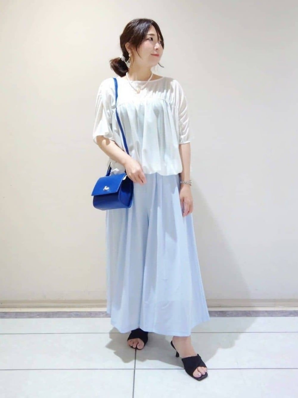 ブルー系のショルダーバッグ、ホワイト系のTシャツ/カットソー、グレー系のその他パンツを着用したレディースの春コーディネートの1枚目の写真