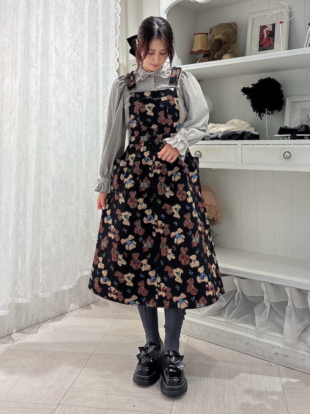 グレー系のシャツ/ブラウス、ブラック系のジャンパースカート、ブラック系のローファーを着用したレディースの秋コーディネートの1枚目の写真