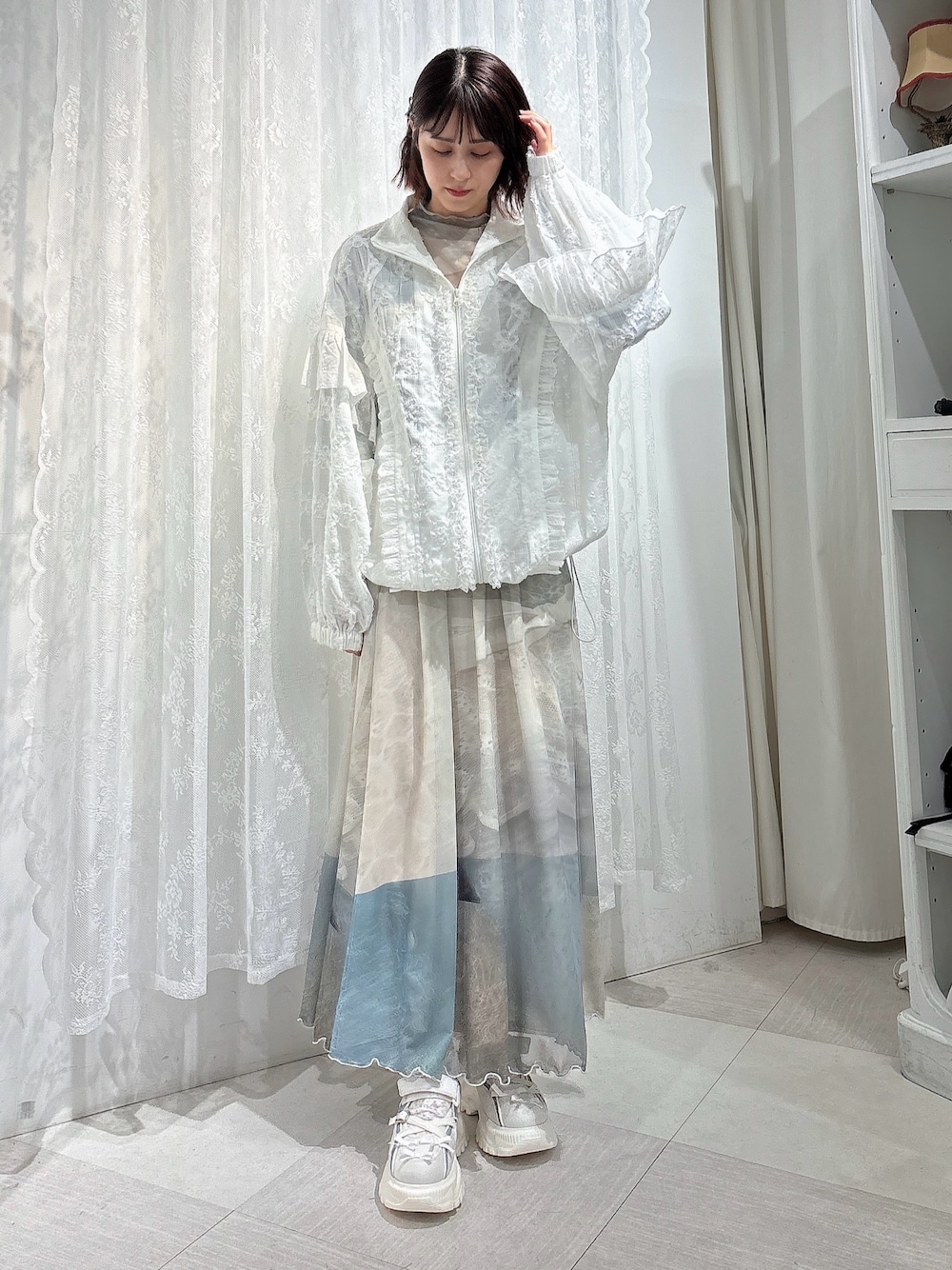 ホワイト系のブルゾン、グリーン系のTシャツ/カットソー、グリーン系のスカートを着用したレディースの春コーディネートの1枚目の写真