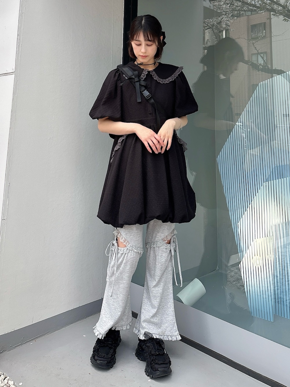 グレー系のスウェットパンツ、ブラック系のスニーカー、ブラック系のワンピースを着用したレディースの春コーディネートの1枚目の写真