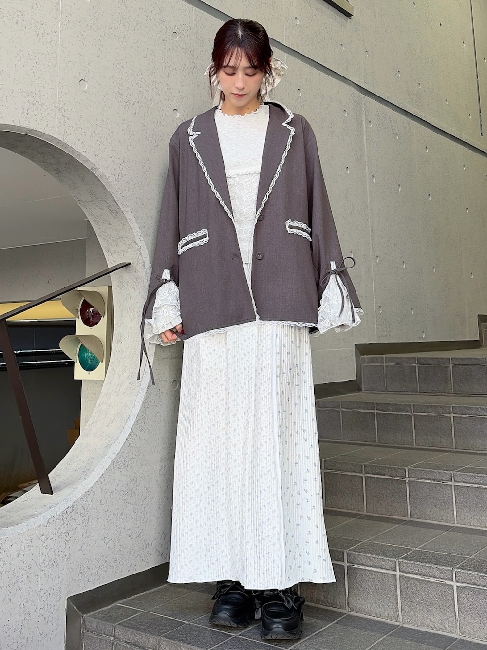 グレー系のテーラードジャケット、グレー系のTシャツ/カットソー、パープル系のスカートを着用したレディースの冬コーディネートの1枚目の写真