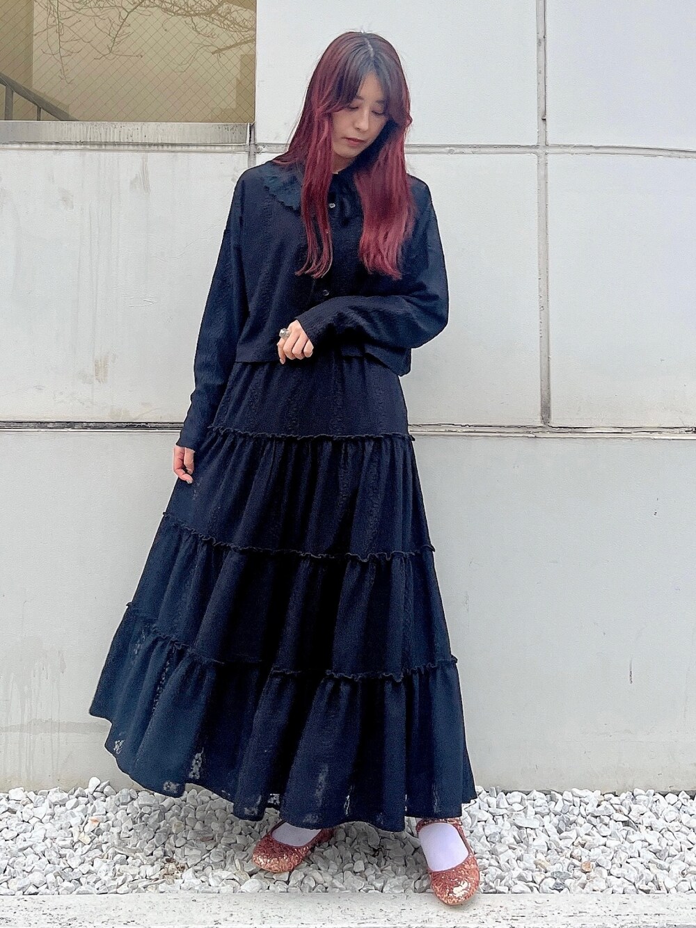 ピンク系のパンプス、ブラック系のスカート、ブラック系のチュニックを着用したレディースの春コーディネートの1枚目の写真