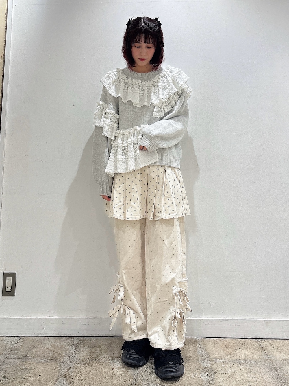 グレー系のニット/セーター、ホワイト系のスカート、ホワイト系のスラックスを着用したレディースの夏コーディネートの1枚目の写真