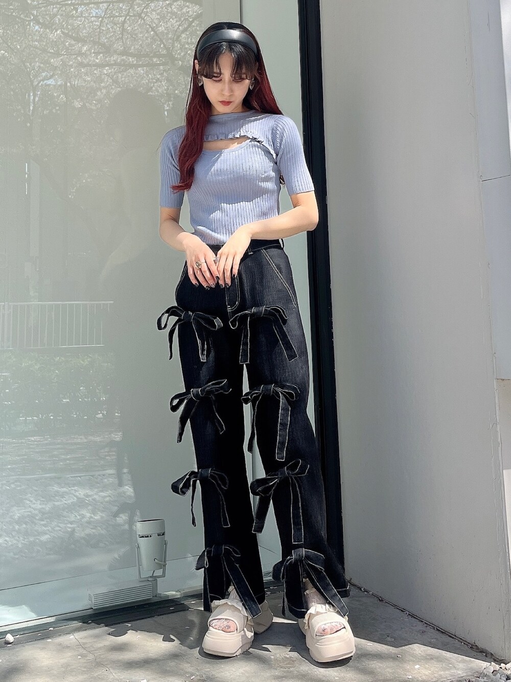 ブラック系のデニムパンツ、ホワイト系のサンダル、ブルー系のニット/セーターを着用したレディースの春コーディネートの1枚目の写真