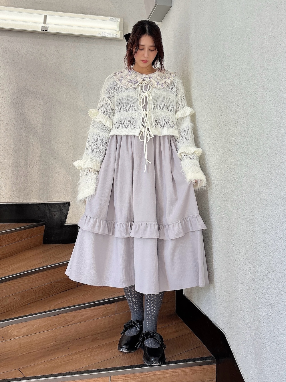 ホワイト系のカーディガン/ボレロ、パープル系のワンピース、ブラック系のパンプスを着用したレディースの秋コーディネートの1枚目の写真