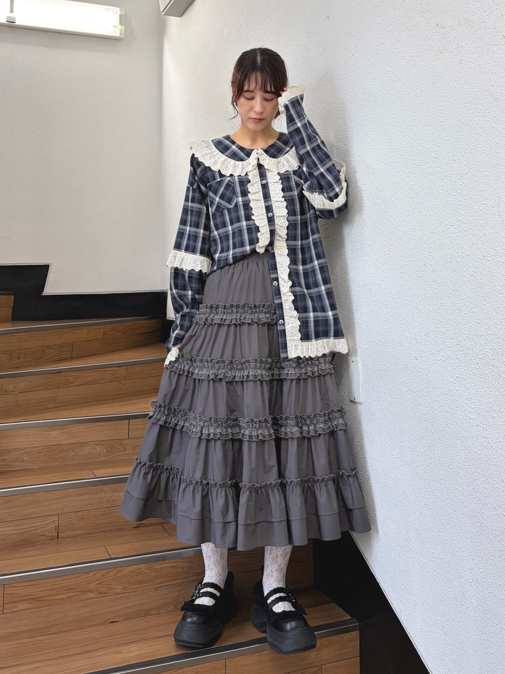 ブルー系のシャツ/ブラウス、グレー系のスカート、ブラック系のスニーカーを着用したレディースの夏コーディネートの1枚目の写真