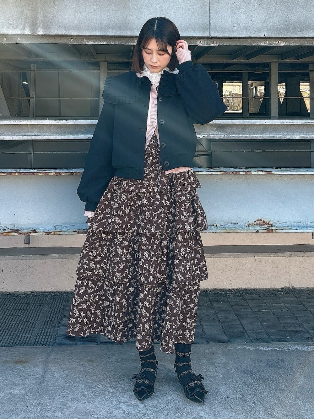 ブラウン系のワンピース、ブラック系のパンプス、ピンク系のカーディガン/ボレロを着用したレディースの冬コーディネートの1枚目の写真