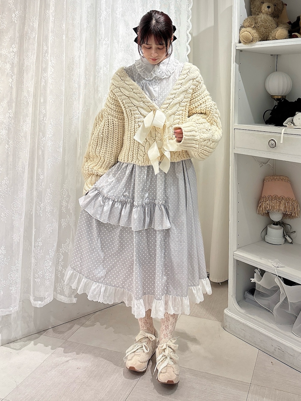 ホワイト系のカーディガン/ボレロ、グレー系のワンピース、ピンク系のスニーカーを着用したレディースの秋コーディネートの1枚目の写真