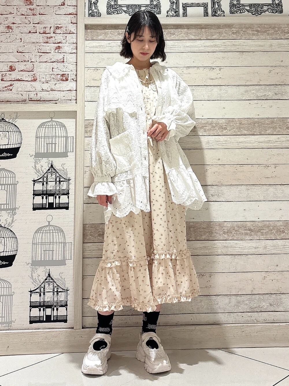 ホワイト系のテーラードジャケット、ホワイト系のワンピース、ホワイト系のスニーカーを着用したレディースの冬コーディネートの1枚目の写真