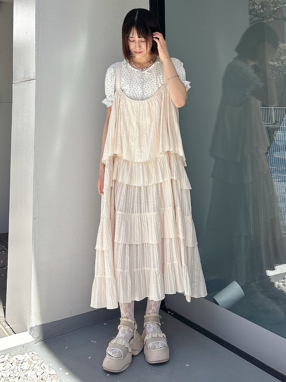 ホワイト系のワンピース、ブルー系のTシャツ/カットソー、ホワイト系のサンダルを着用したレディースの春コーディネートの1枚目の写真