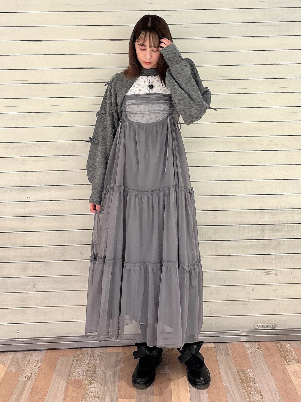 グレー系のワンピース、ブラック系のバレエシューズ、グレー系のカーディガン/ボレロを着用したレディースの秋コーディネートの1枚目の写真