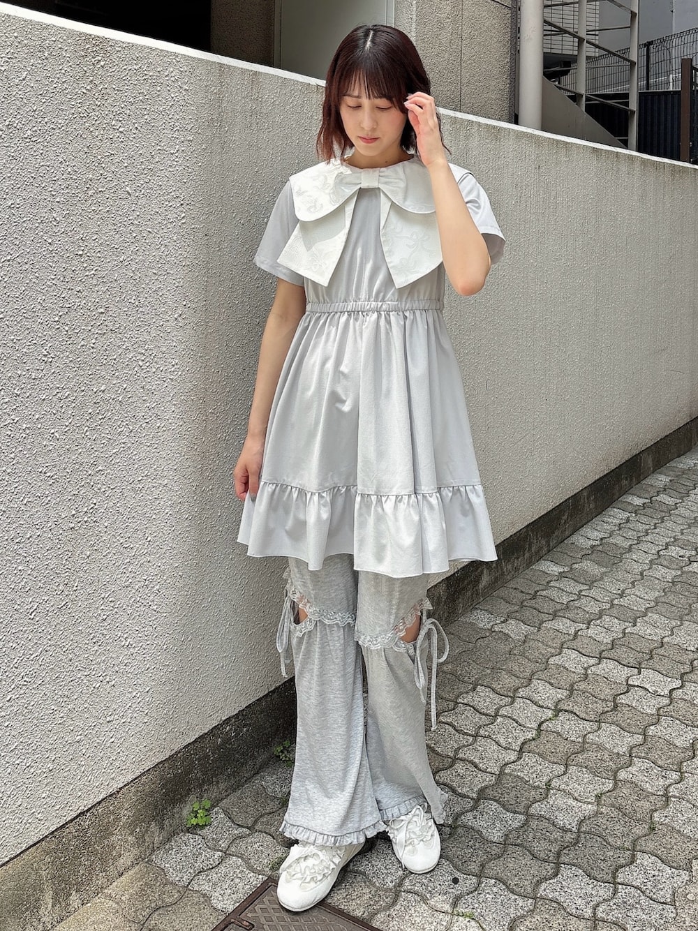 ブルー系のワンピース、グレー系のスウェットパンツ、ホワイト系のスニーカーを着用したレディースの春コーディネートの1枚目の写真