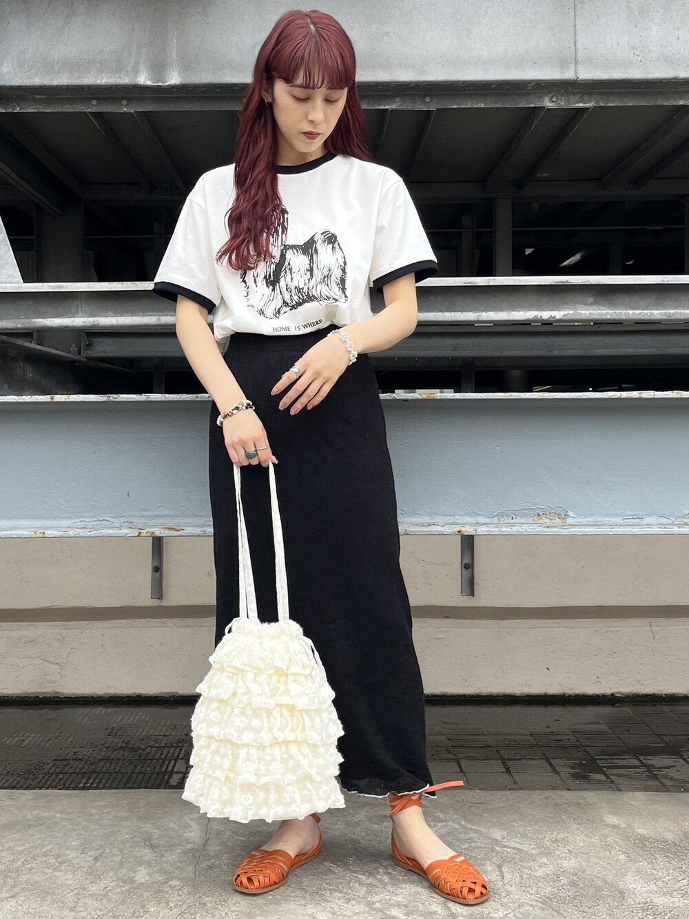 ブラック系のスカート、ホワイト系のTシャツ/カットソー、オレンジ系のパンプスを着用したレディースの春コーディネートの1枚目の写真