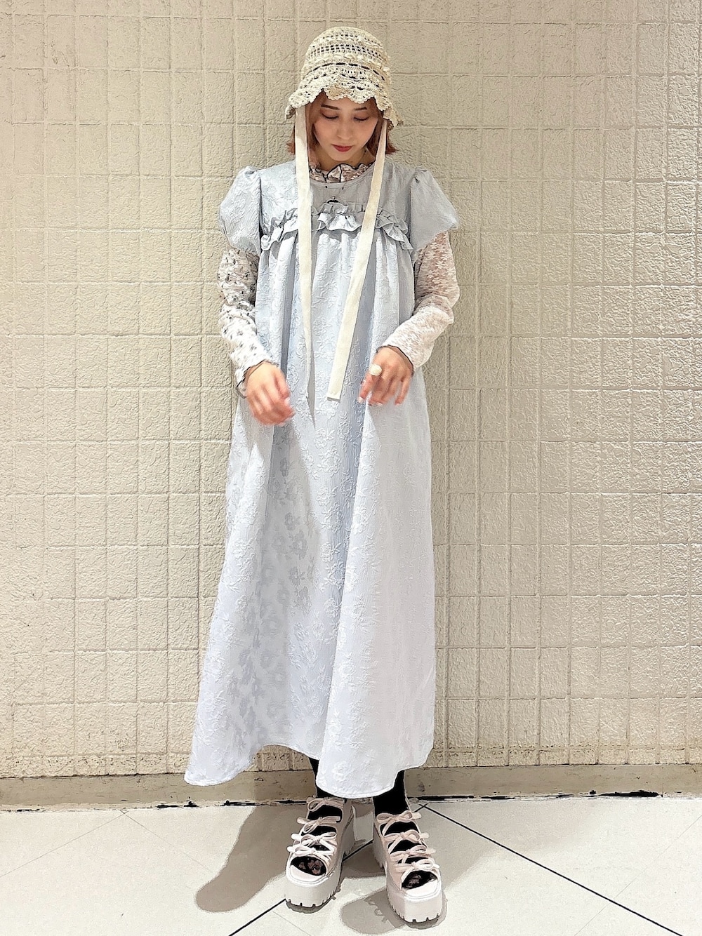 ブルー系のワンピース、ホワイト系のTシャツ/カットソー、ホワイト系のサンダルを着用したレディースの春コーディネートの1枚目の写真