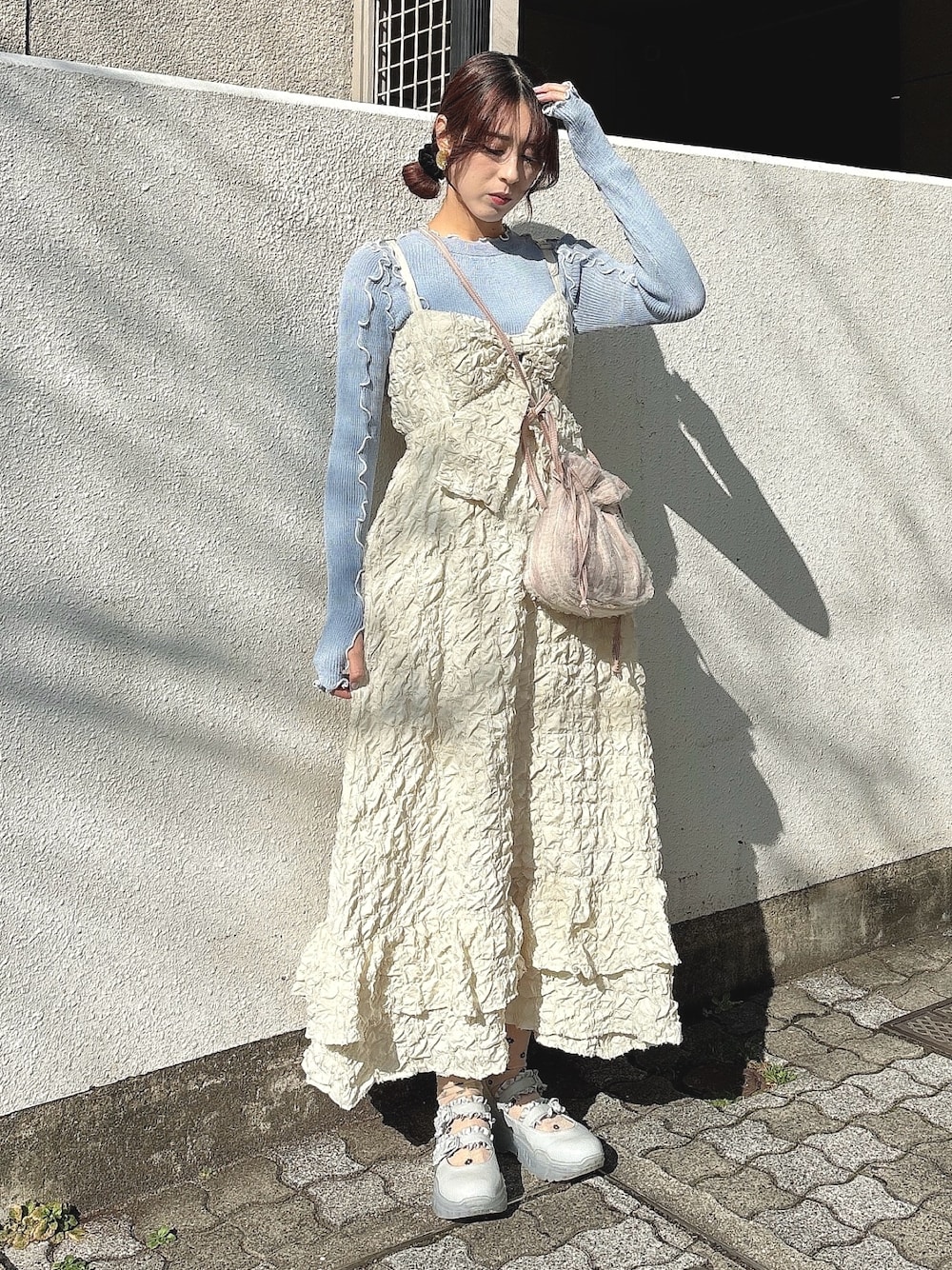 ピンク系のショルダーバッグ、ベージュ系のワンピース、ブルー系のTシャツ/カットソーを着用したレディースの冬コーディネートの1枚目の写真